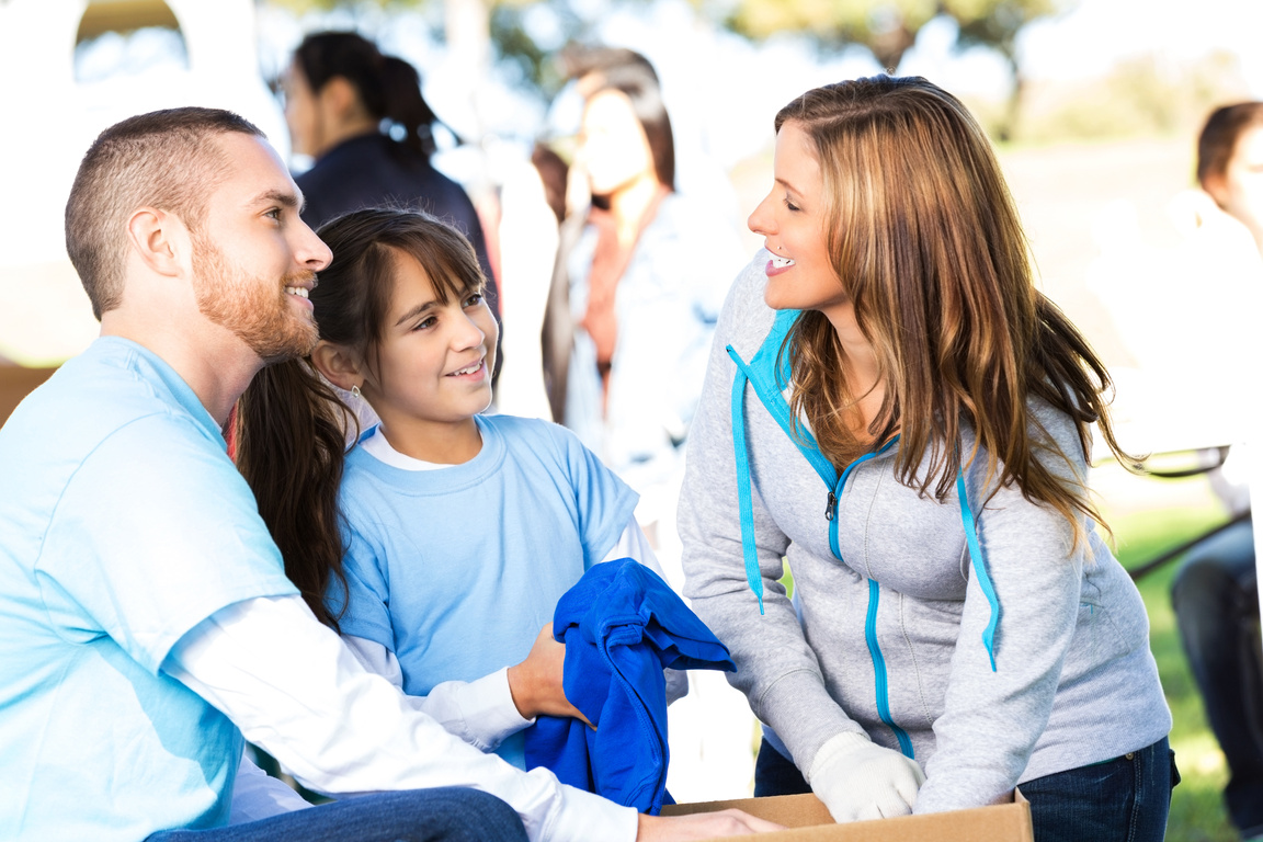 Young family donating clothing at charity event